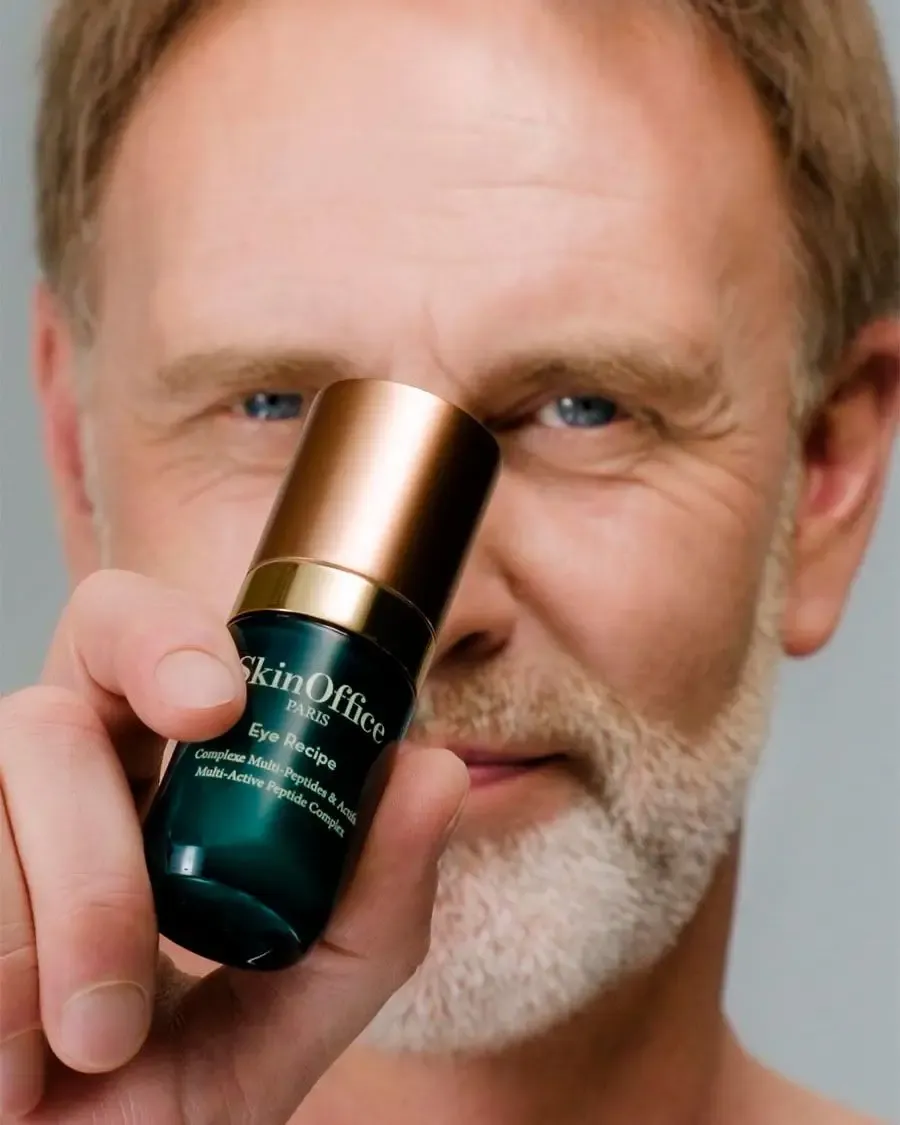 Un homme montre le soin contour des yeux eye Recipe, soulignant l’importance des soins de la peau dans sa routine quotidienne